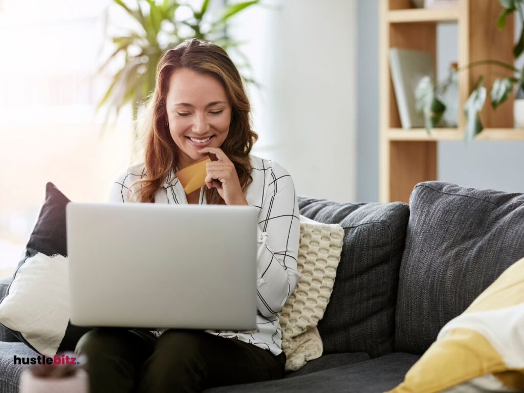 woman smiles while holding laptop