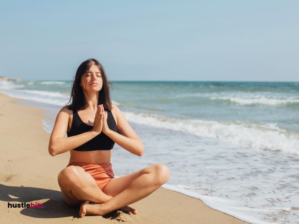 a woman doing meditation beside the sea