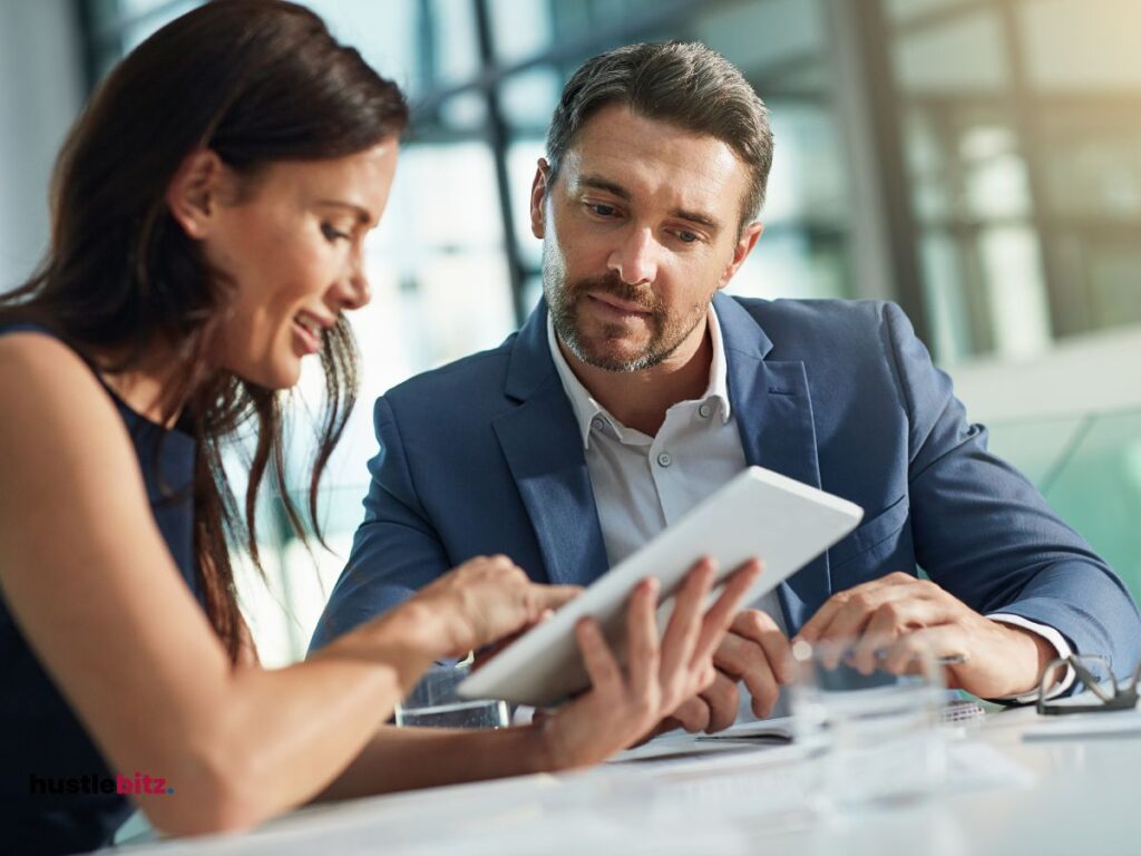 A man and woman talking each other and a woman holding a tablet