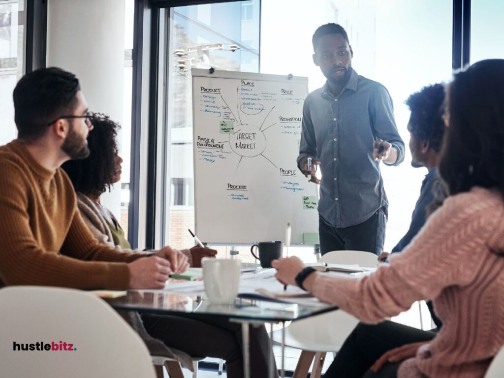 a man standing in front of other people talking about business