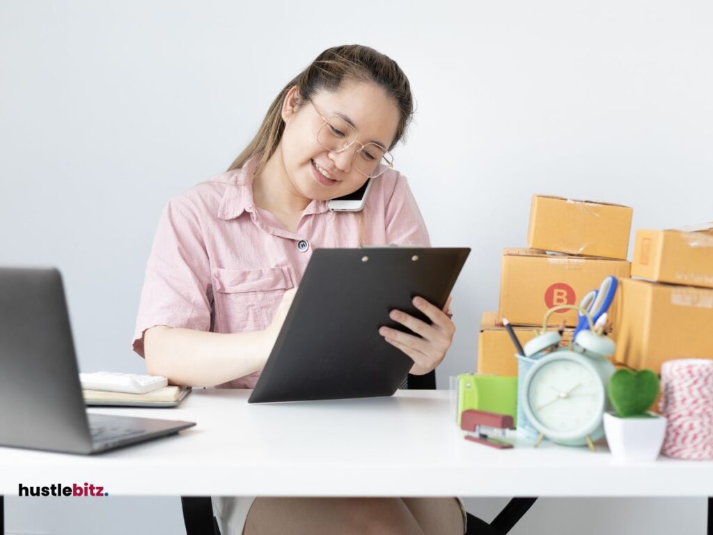 A woman wearing eyeglass smiles while doing writing and calling 