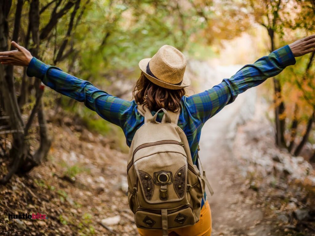 A woman wearing a bag and a hat facing the natures