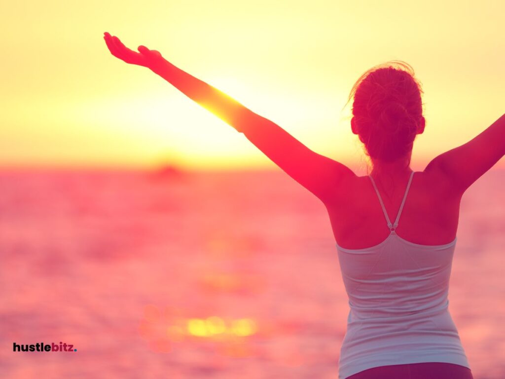 A woman facing the sea with sunset background