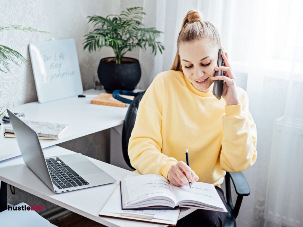 A woman holding a cellphone and a pen with notebook