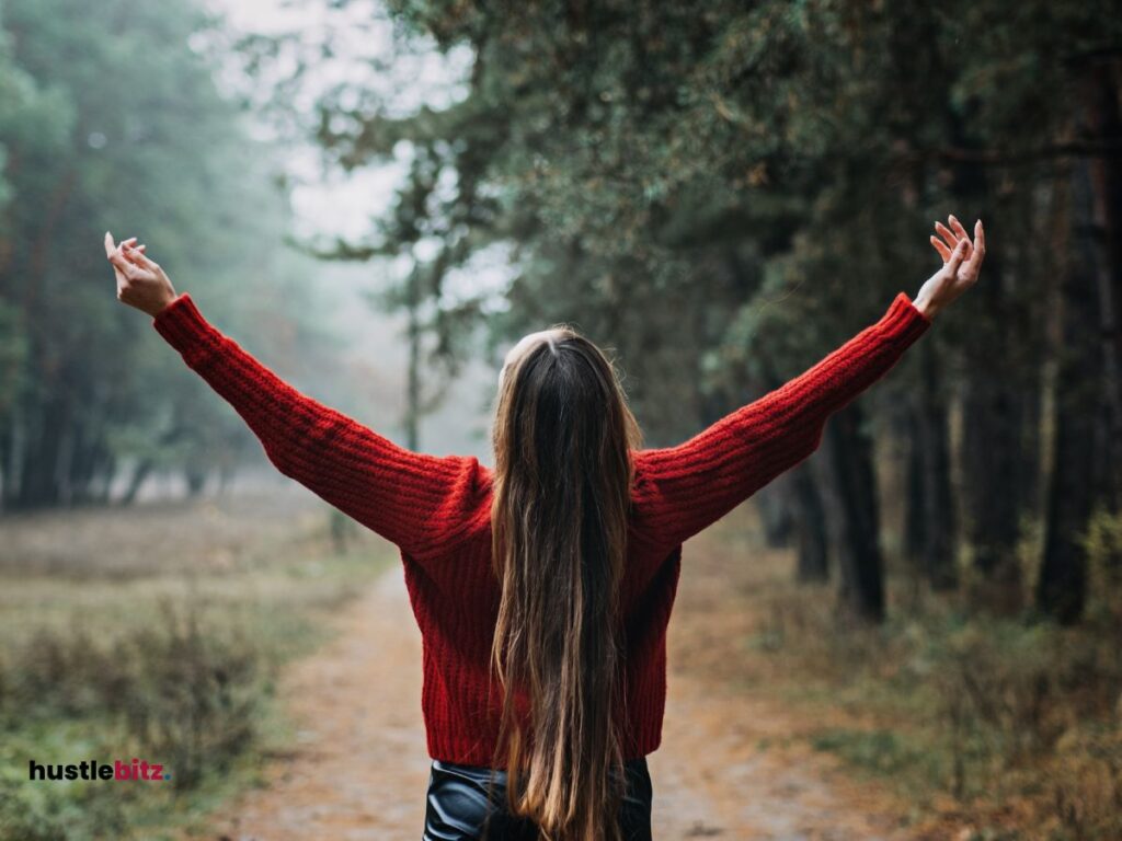 A woman up her two hands in front of the nature