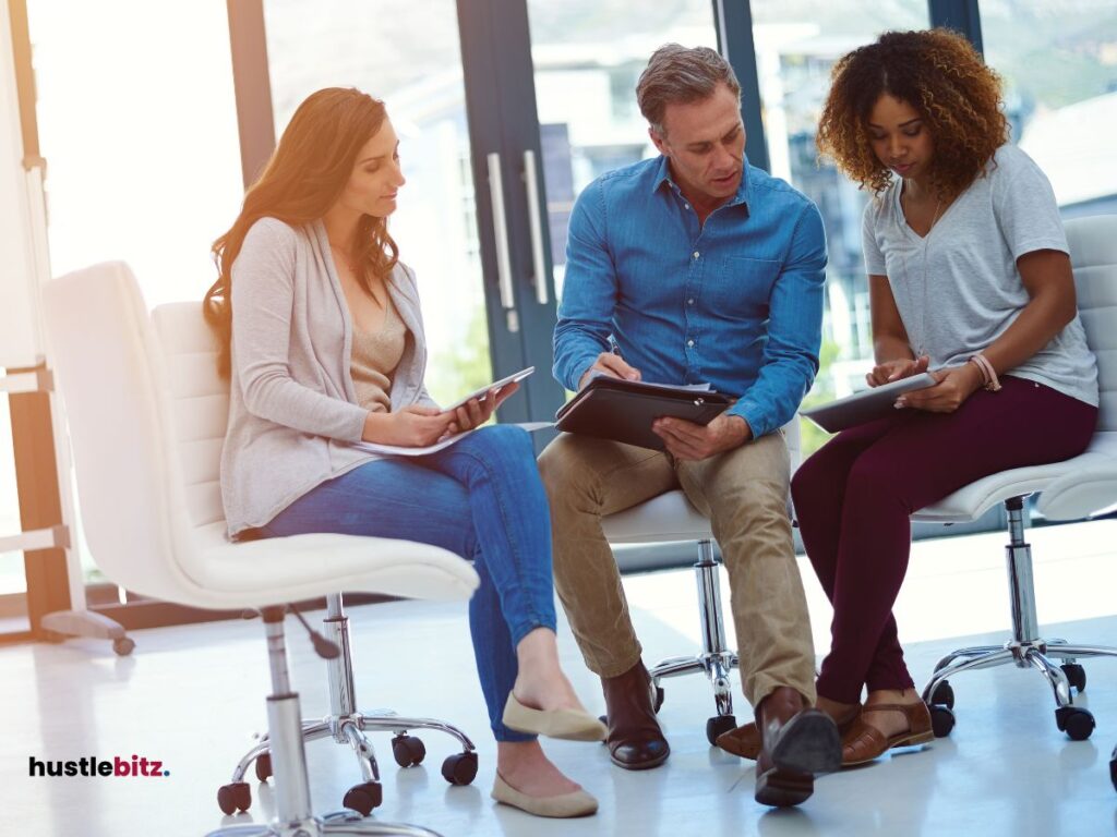 Three people holding tablet while chatting