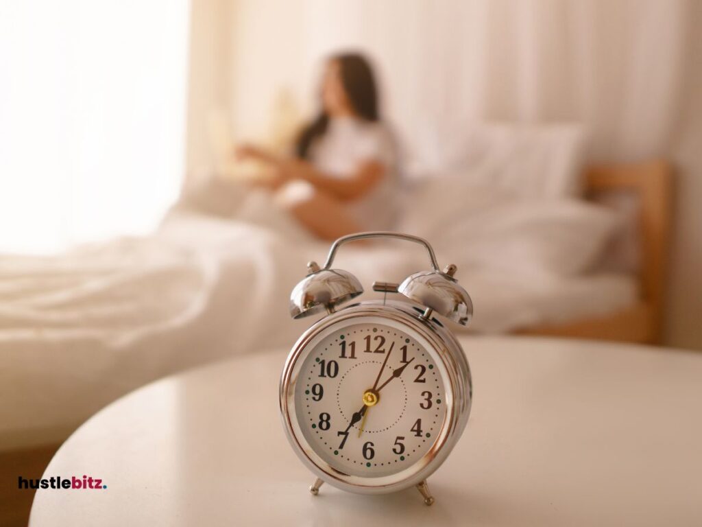 A woman in the bed and a clock in the table