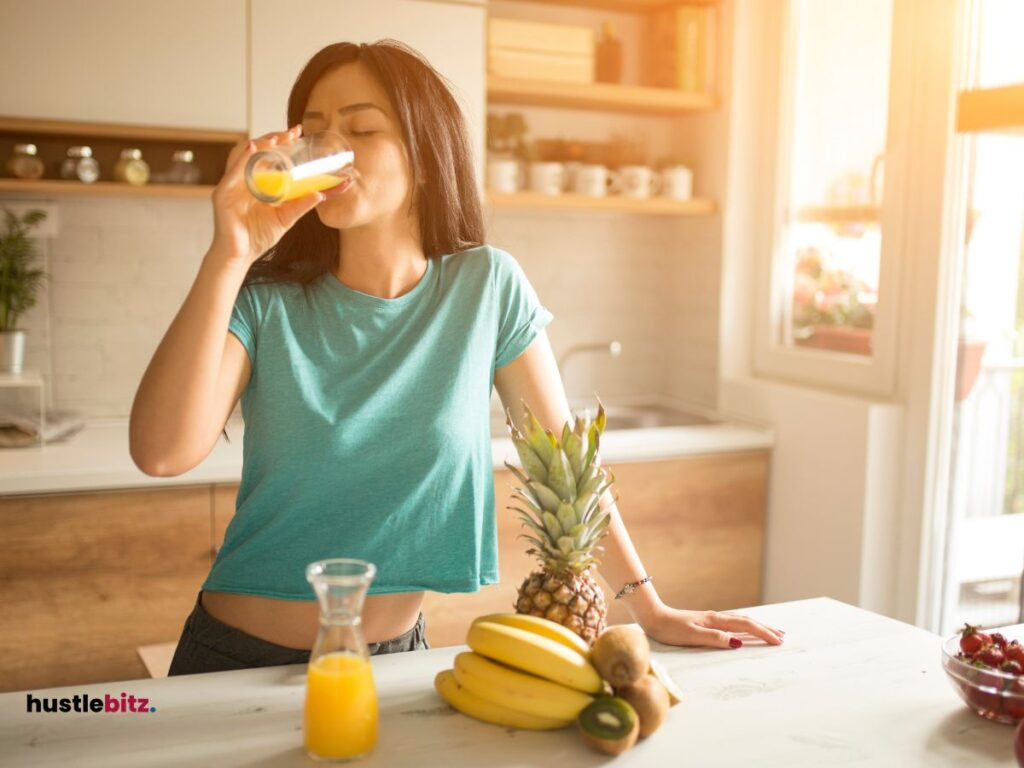 A woman drink and juice and a fruits in the table