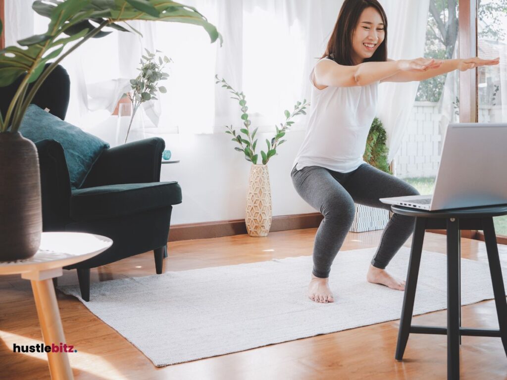 A woman doing exercise while watching on her laptop inside the house