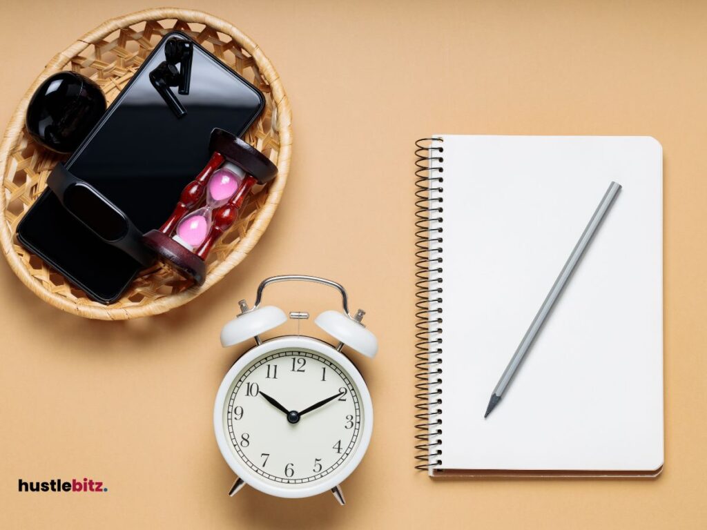 A clock, notebook, pencil and a gadgets