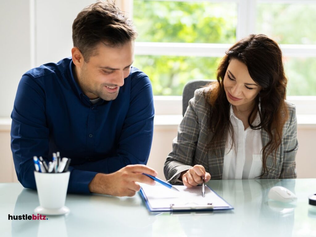 A man and woman talking and pointing the paper