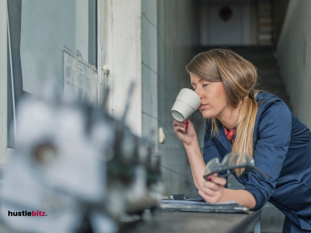 A woman drinking a coffee inside the office