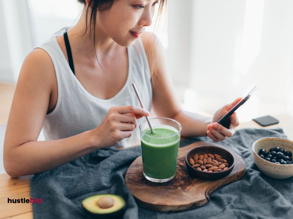 A woman holding a straw with a glass of coffee while holding a cellhpone