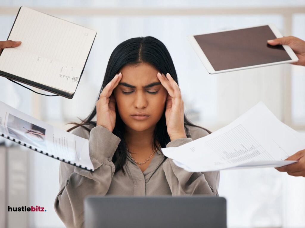 a woman holding her head and a hand holding a paper