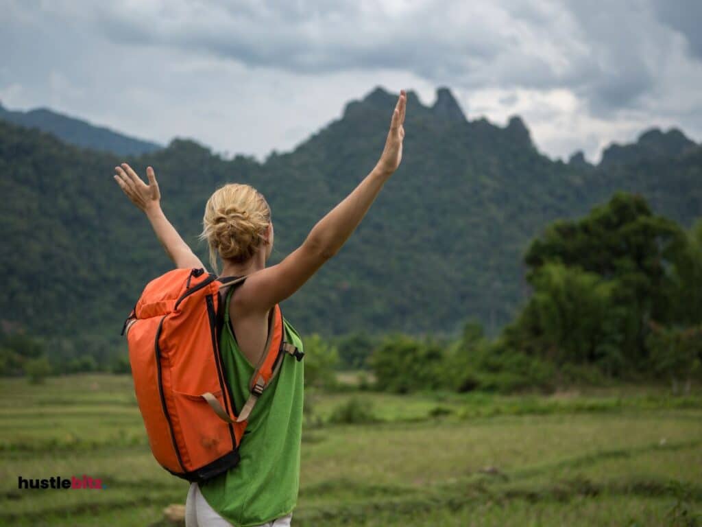 A woman wearing bag pack and a background of mountain