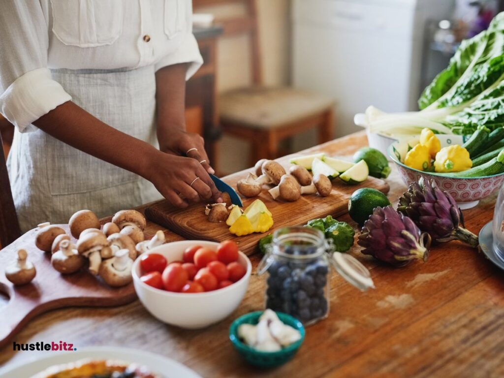 A woman holding a knife doing  cutting on the fruits in the table and different types of vegetables