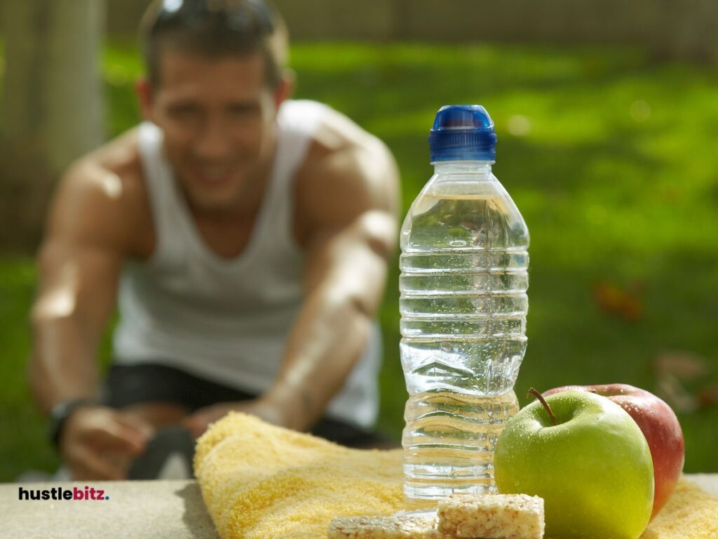 A man doing exercise and a bottle of water with fruits in the table