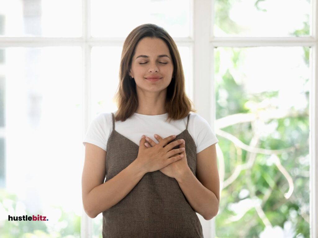 A woman hold her check with 2 hands inside the house