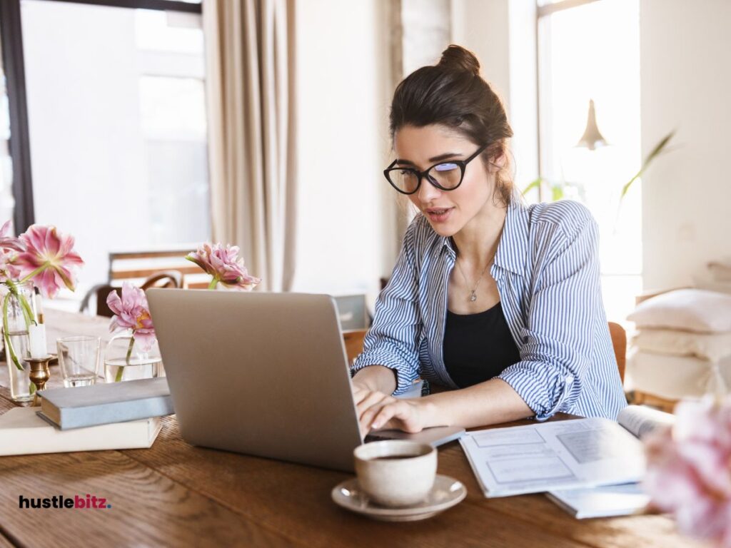 A woman wearing eyeglass and a laptop in the table