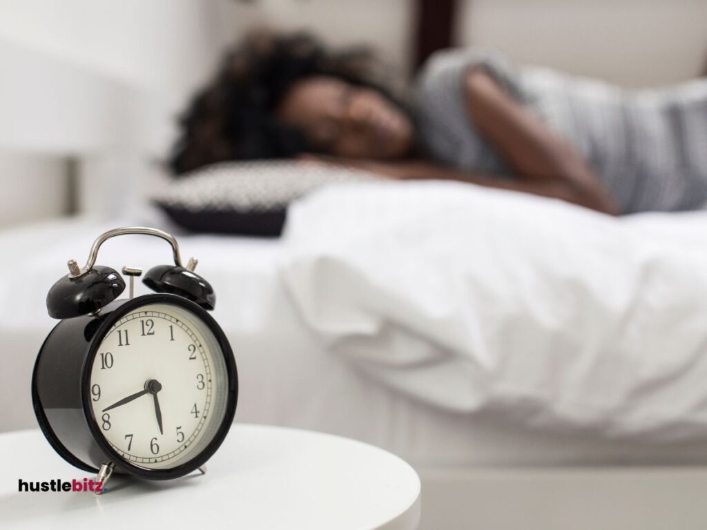 A woman sleep in the bed and a clock in the round table