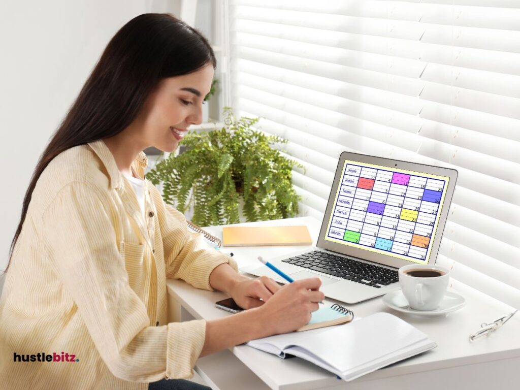 A woman smiles while writing in front of the laptop