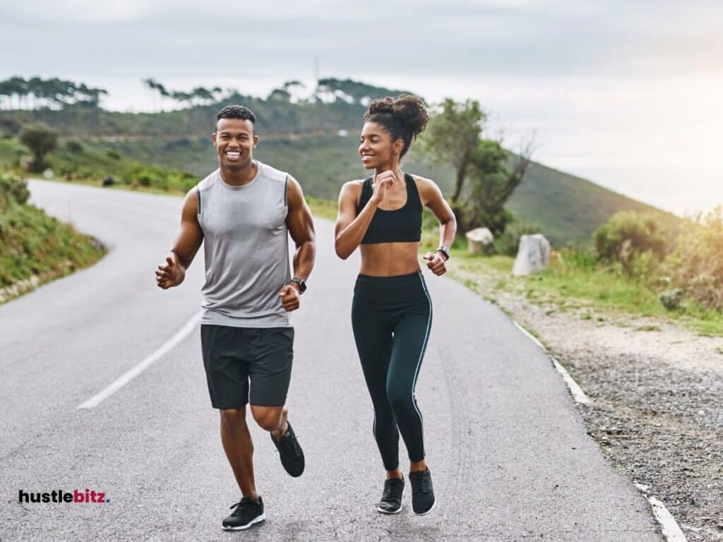 A young man and woman jogging on a scenic road.