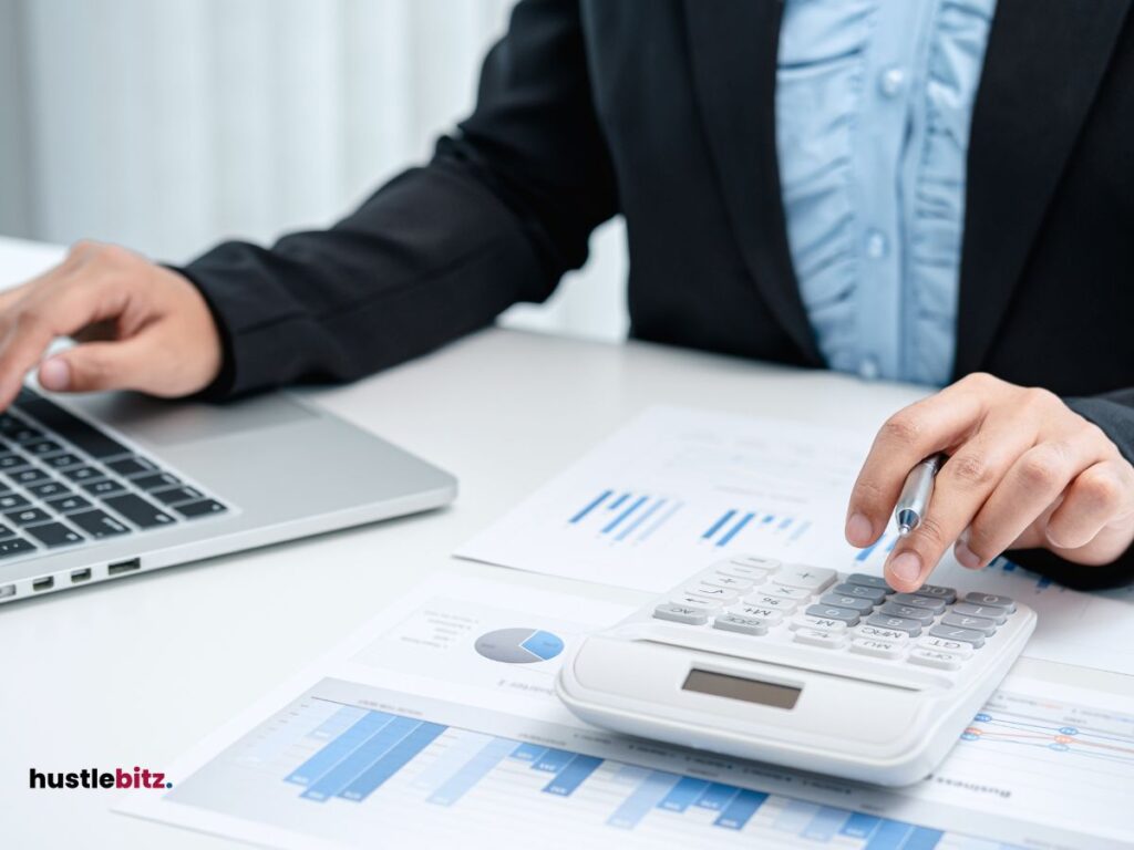 A man clicking the calculator and laptop in the table