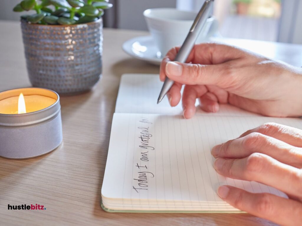 A hand holding a pen with a notebook in the table