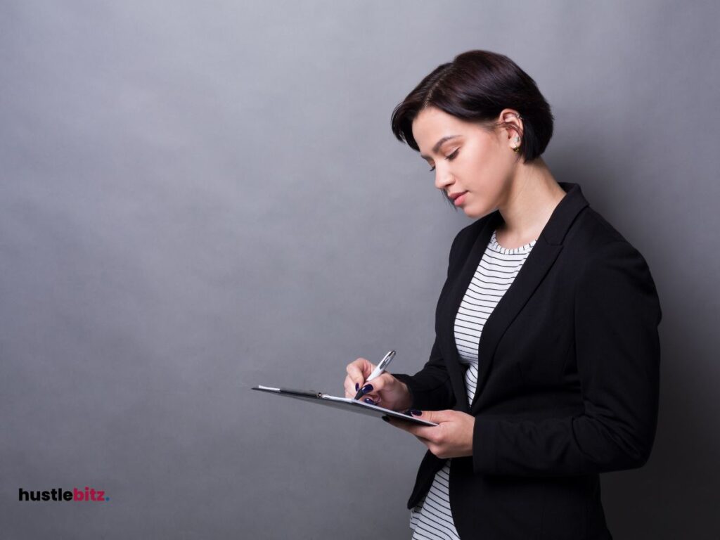 A woman wearing black blazer and doing writing