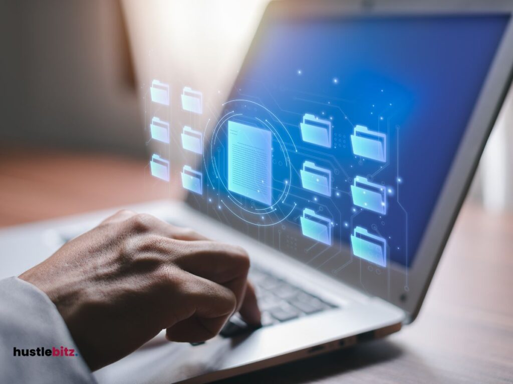 A hand clicking the keyboard of a laptop in the table