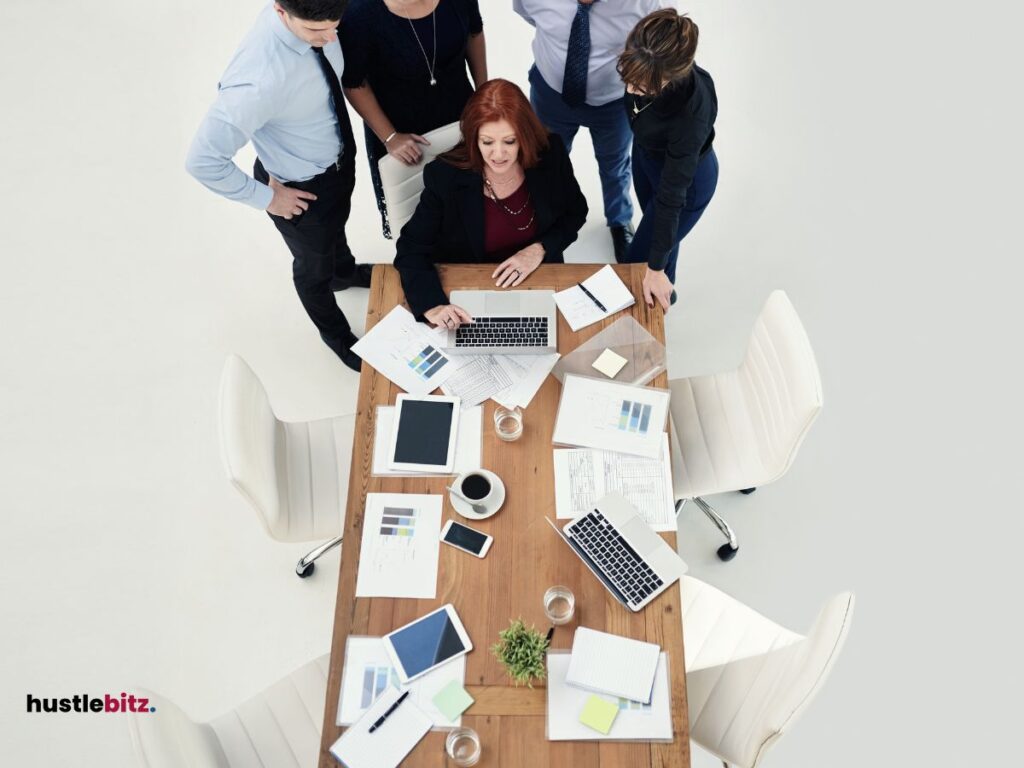 group of people chatting each other and look to the laptop