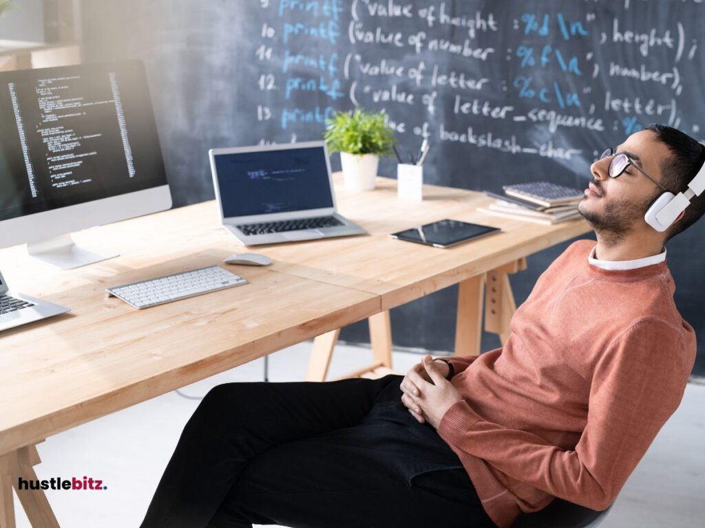 A man wearing headset and a table with laptop and monitor