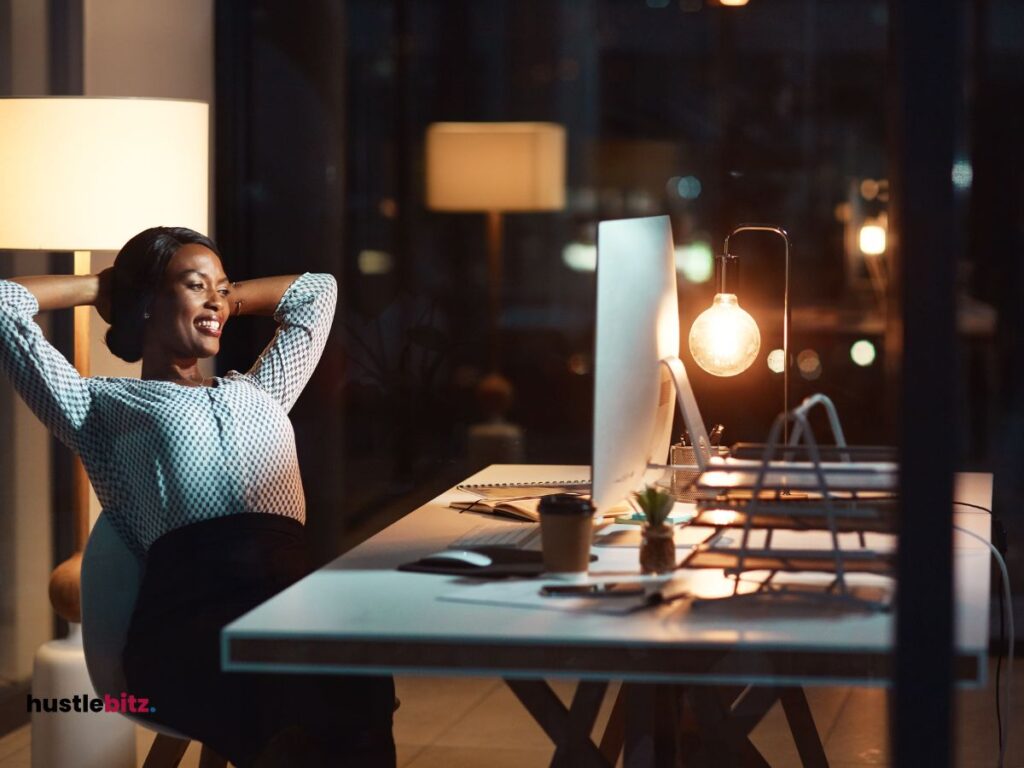 A woman smiles while looking at the monitor