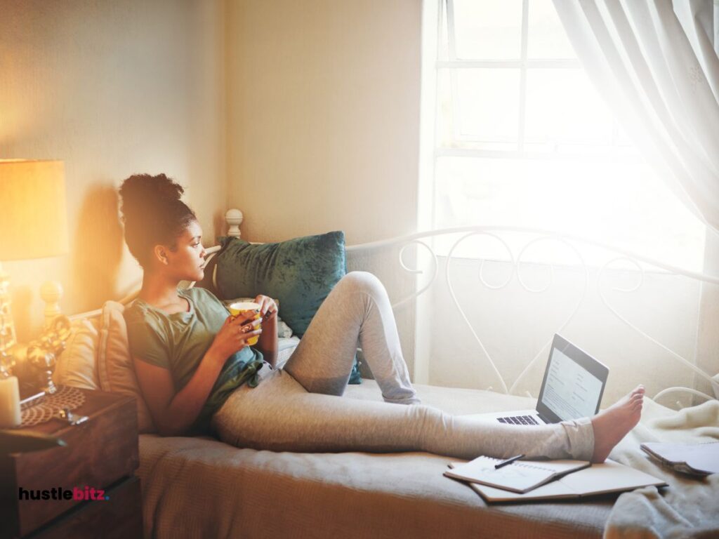 A woman lay down the bed holding a cup