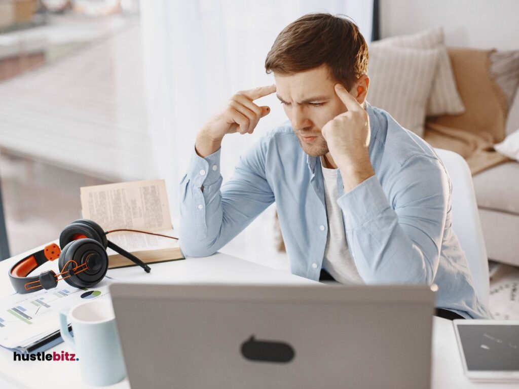 A man sitting in front of the laptop thinking something and a books