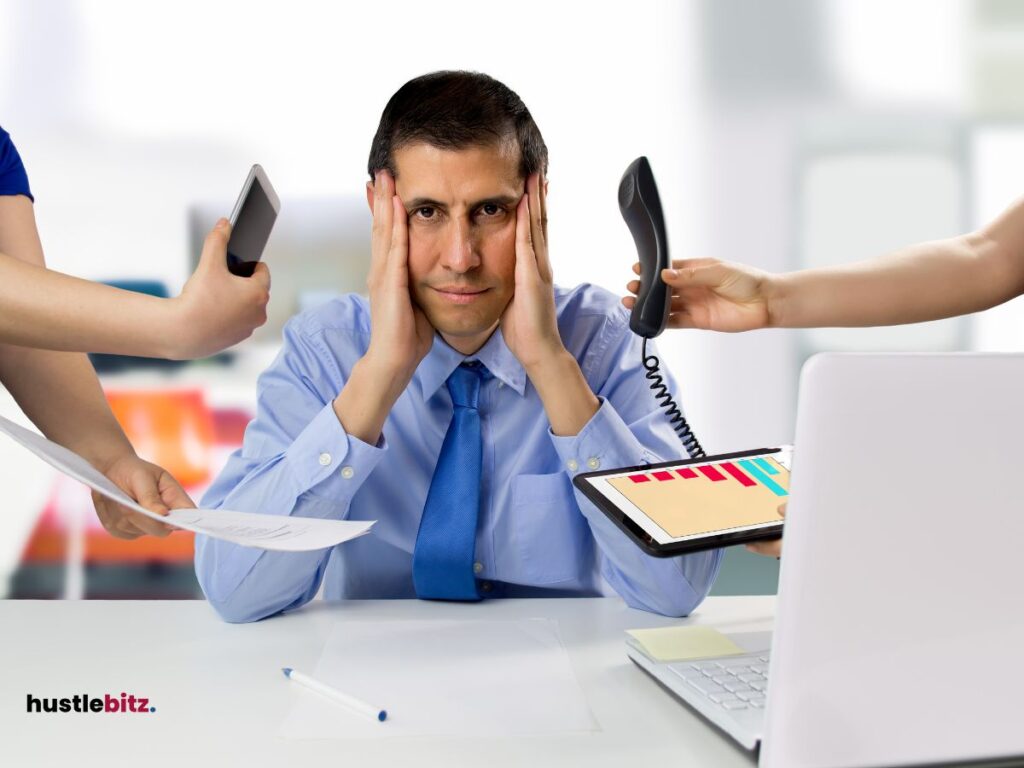 A man holding his face and a different hands holding gadget and paper