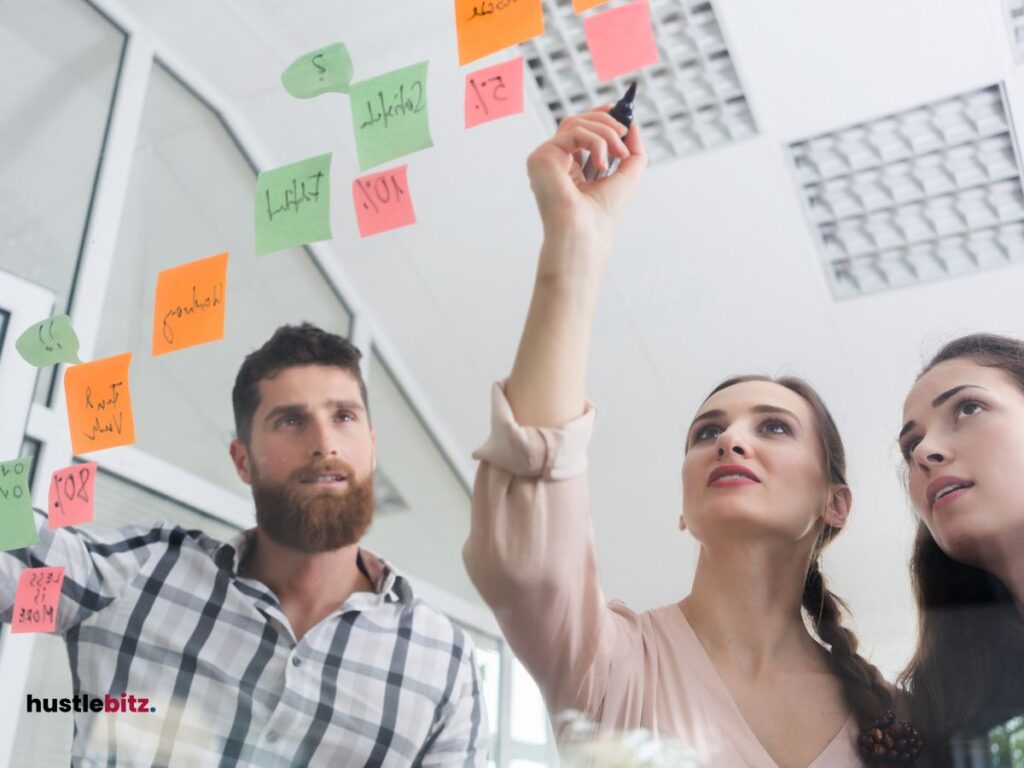 A man and two women chatting and pointing the sticky notes