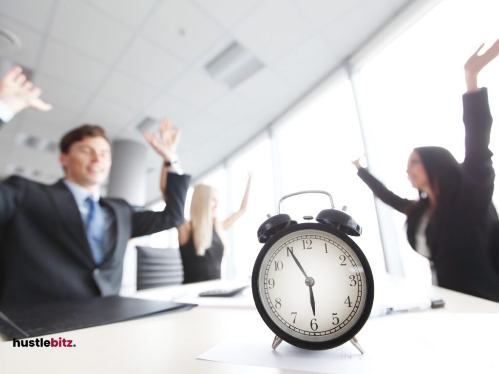 A man and two women up their hands and a clock on the table