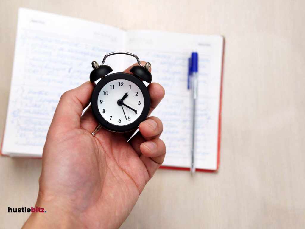 A hand holding a clock and a pen with notebook background