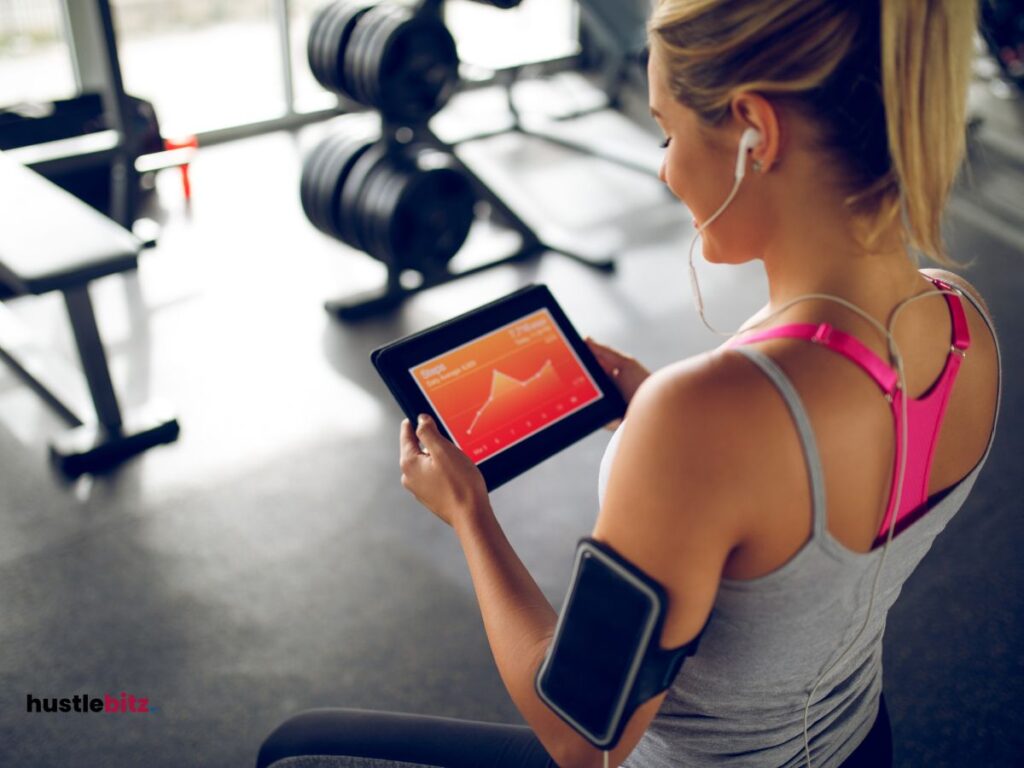 A woman holding a tablet in a gym.