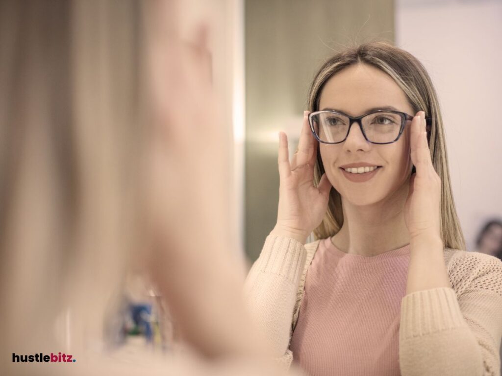 A woman wearing eyeglass looking at the mirror