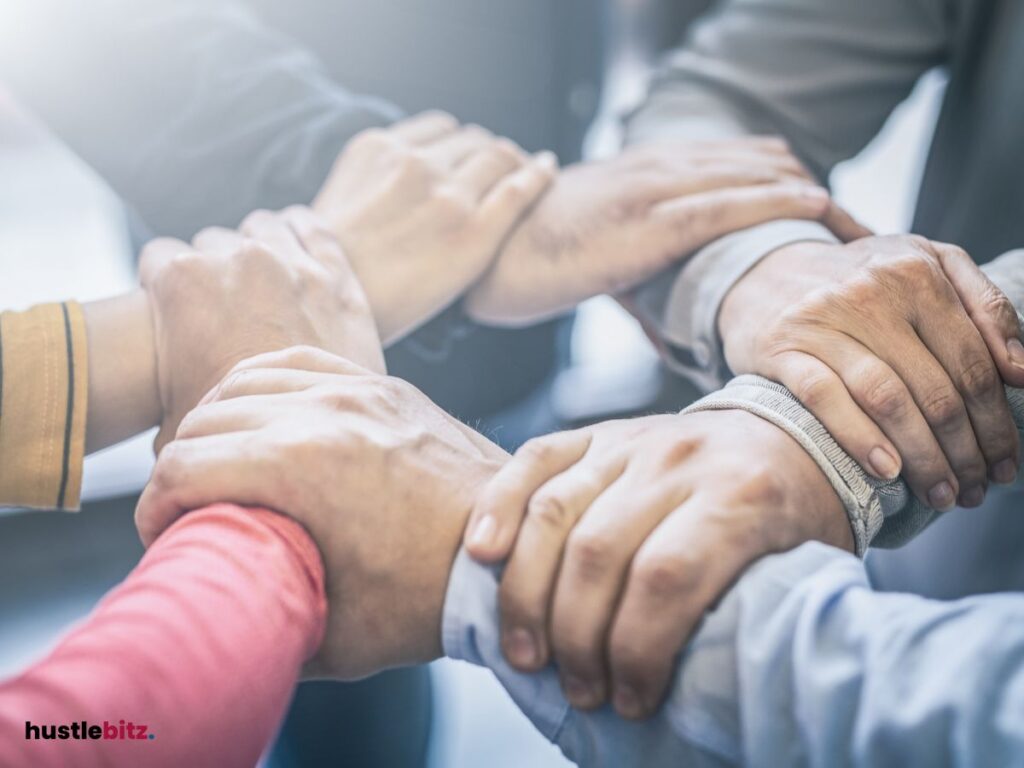 A group of people hold their hands tight