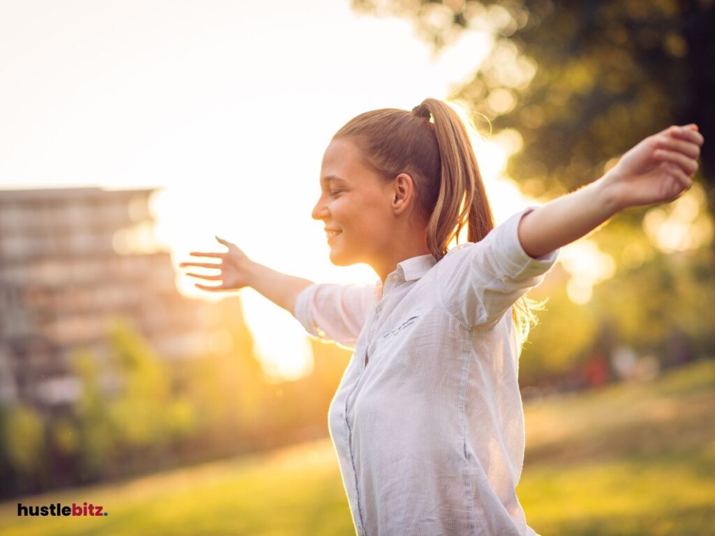 A woman raise her two hands and smiles