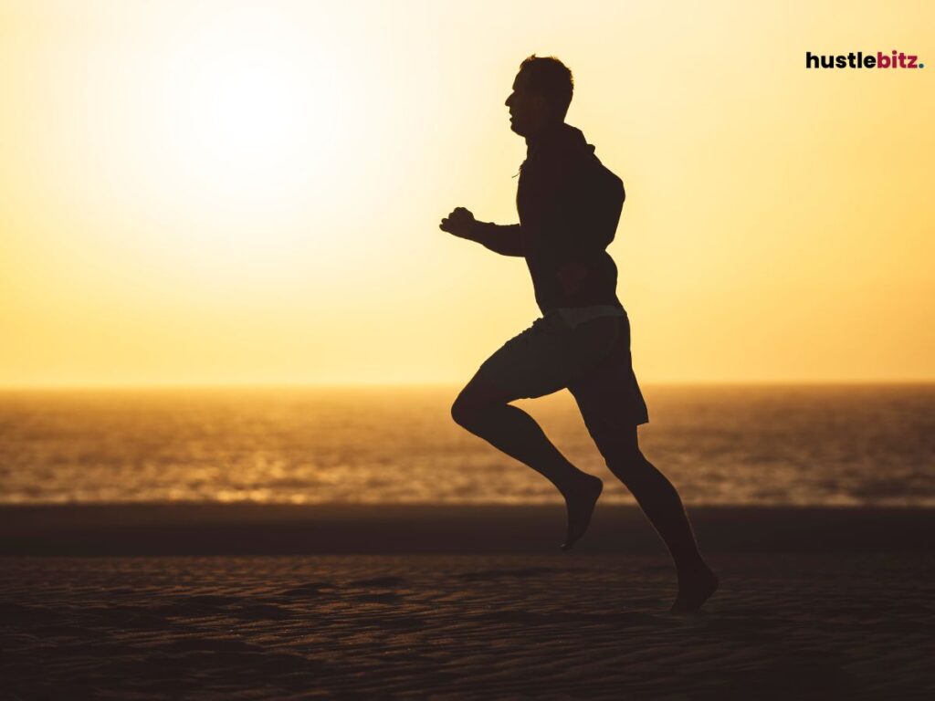 A silhouette of a man running under the sunset.
