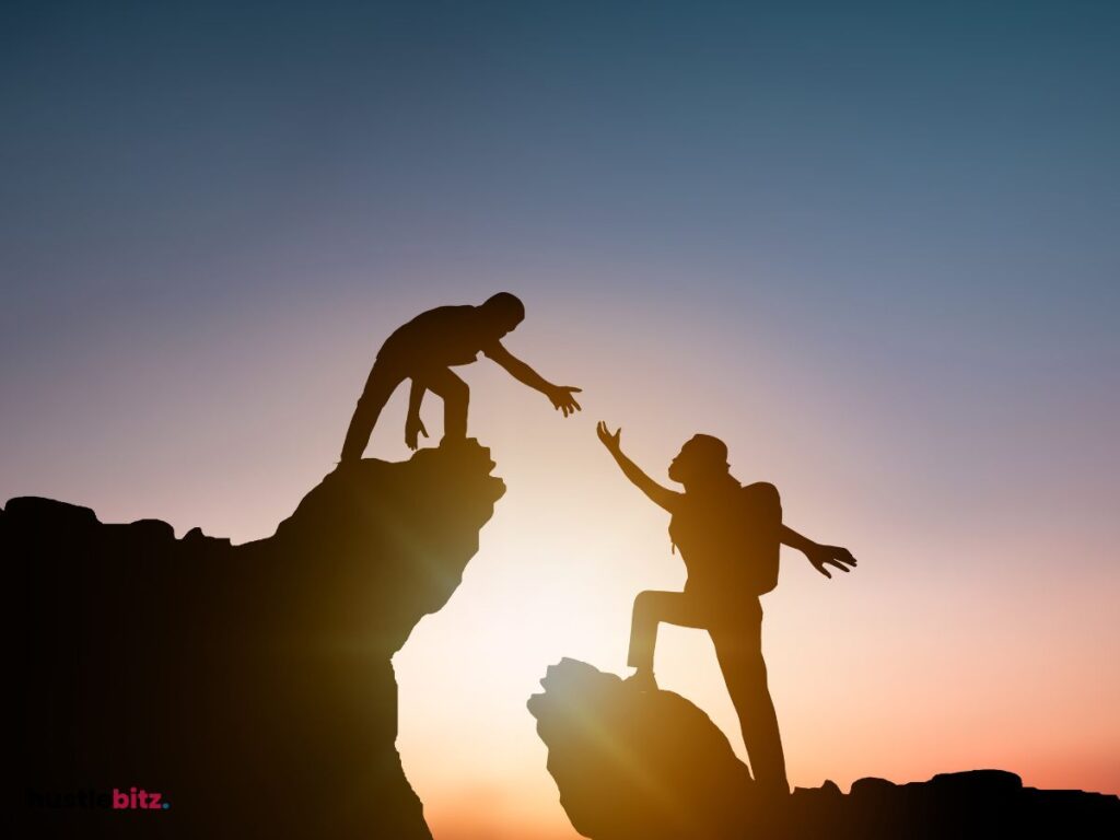two person help each other between the two rocks