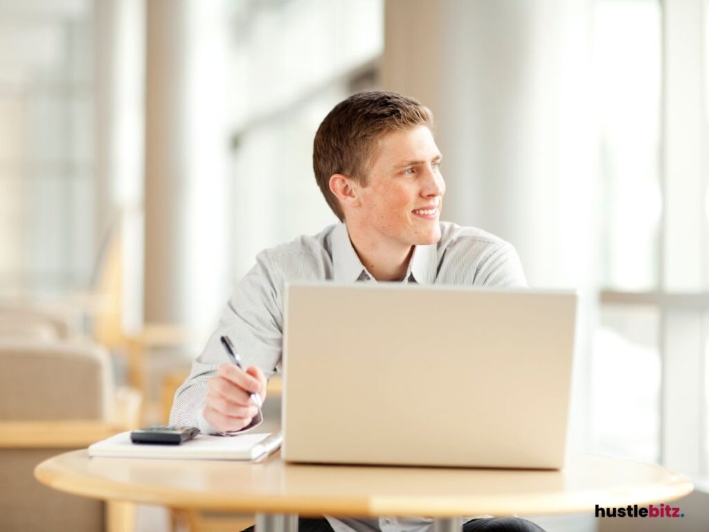 a man look up at the left side of the windows while holding a pen