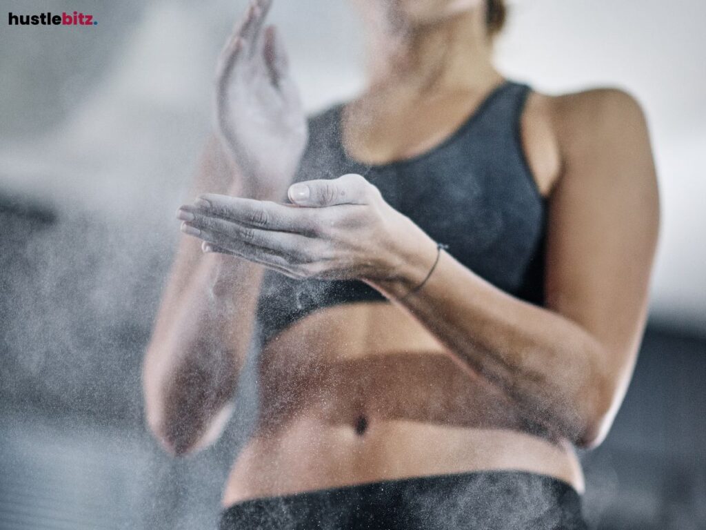 A close-up of a woman's hands dusting off chalk or powder.