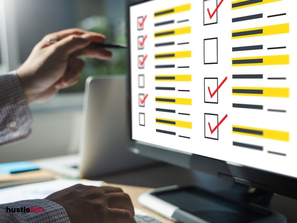 A hand holding a pen pointing the monitor