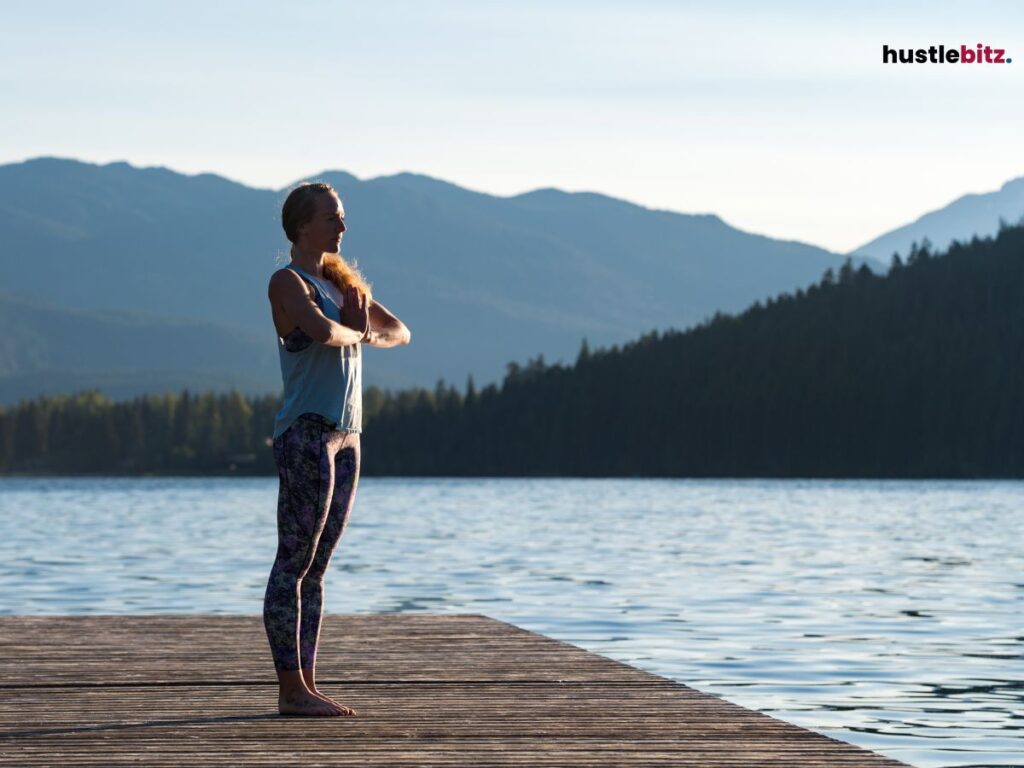 A woman doing meditation beside the lake