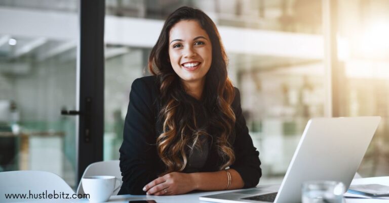 A woman on her desk smiling at the camera.